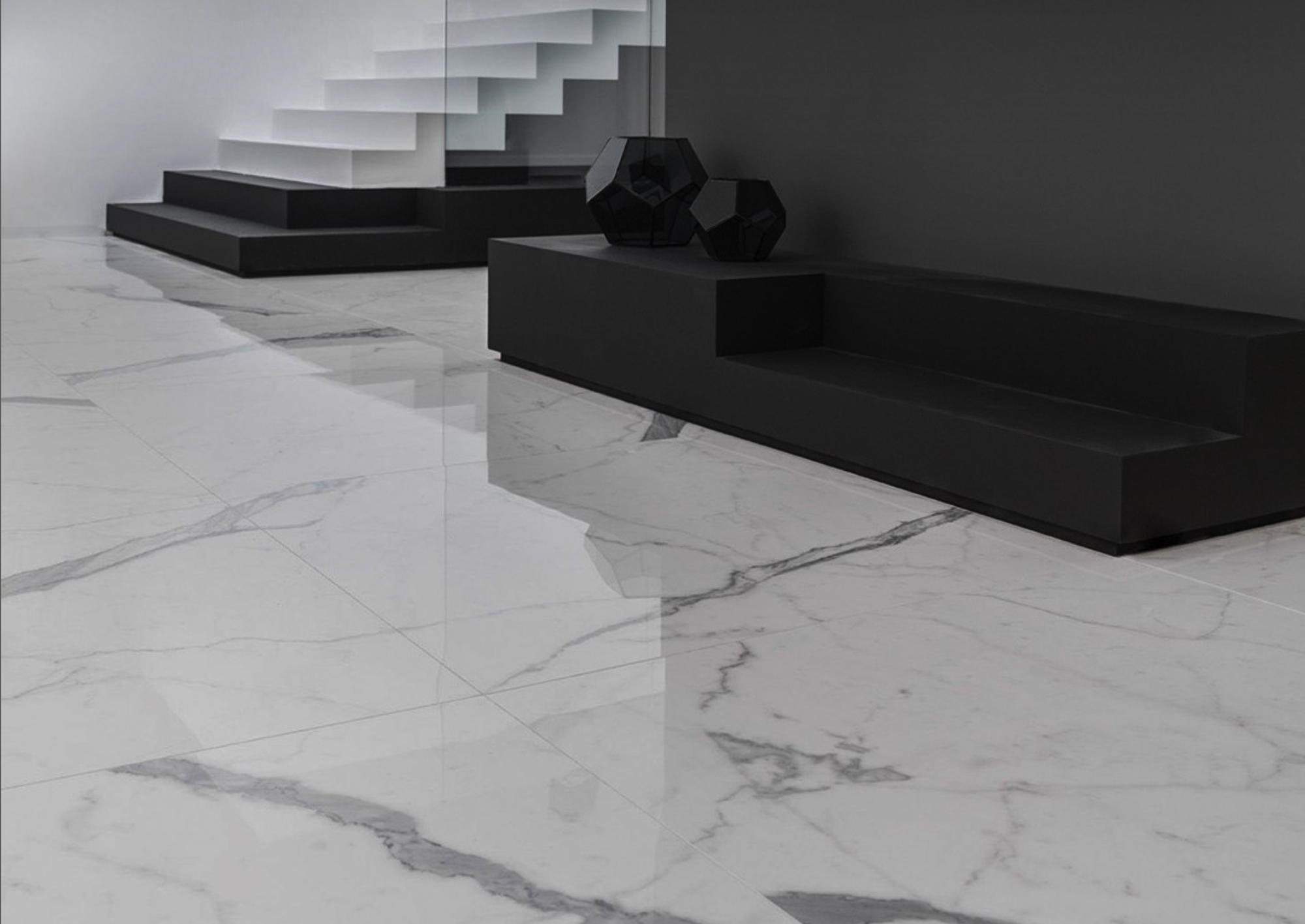 Habitación con suelo de gres porcelánico pulido con efecto mármol, mobiliario blanco y negro.